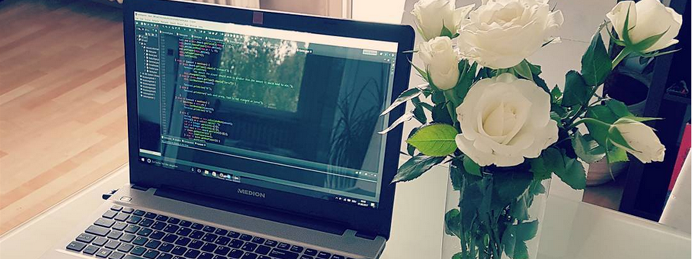 A picture of my laptop with roses next to it.